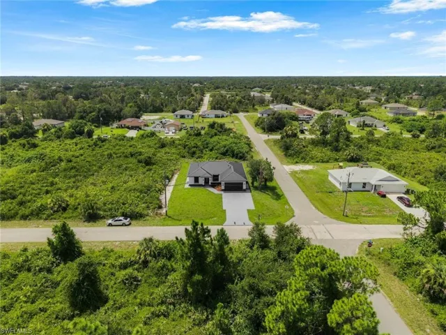 Single-story residence with a dark-tiled roof, concrete driveway, and attached two-car garage