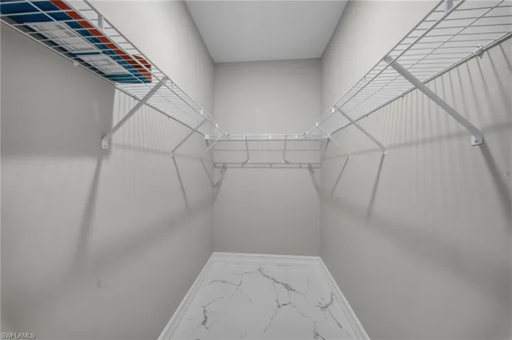 White wire shelving system with a lower counter surface featuring a marble-look finish