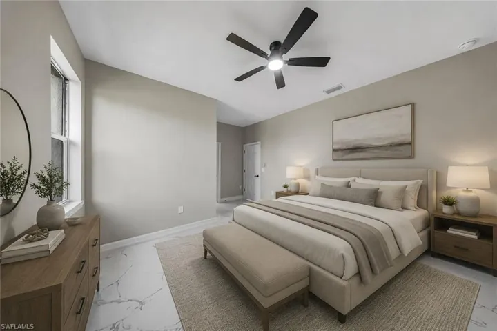 Vaulted ceiling with a ceiling fan, window with textured glass, light-toned walls, and large format tile flooring