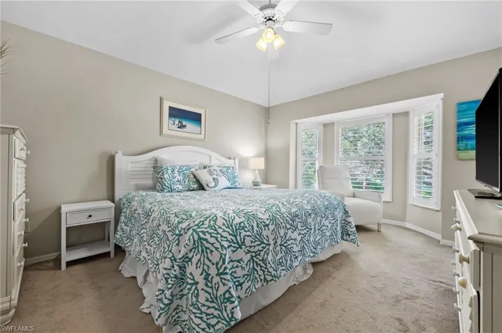 Bedroom with light carpet and a ceiling fan
