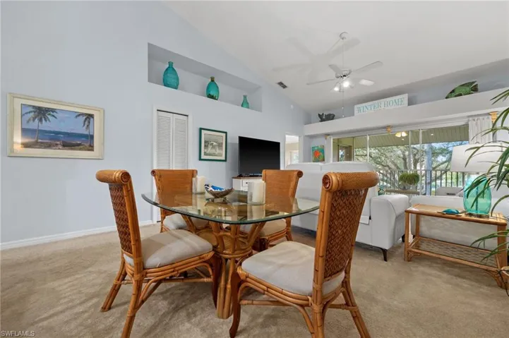 Dining space featuring high vaulted ceiling, carpet flooring, and ceiling fan