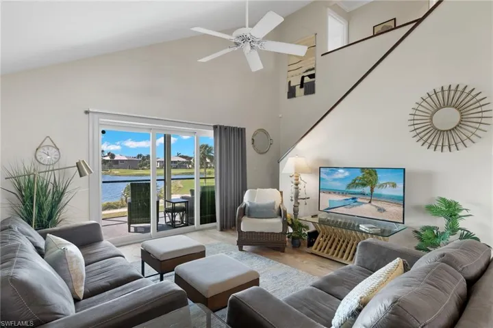 Living room featuring wood finished floors, high vaulted ceiling, and a ceiling fan