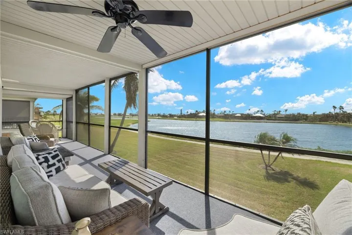 Sunroom / solarium with a water view and ceiling fan