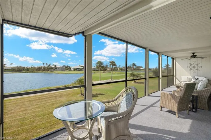Sunroom featuring a water view, view of golf course, and a ceiling fan