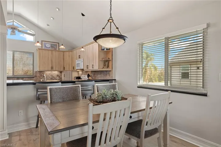 Dining area featuring light wood-style floors and high vaulted ceiling