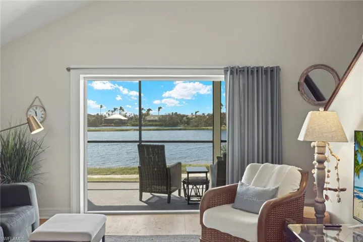 Living area featuring wood finished floors, a water view, and lofted ceiling