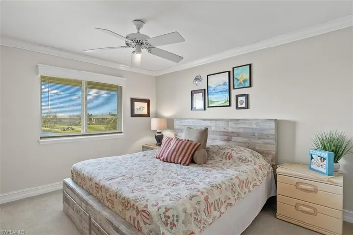 Bedroom with carpet flooring, crown molding, and ceiling fan