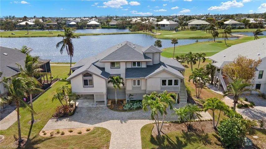Aerial perspective of suburban area with a large body of water and a golf course
