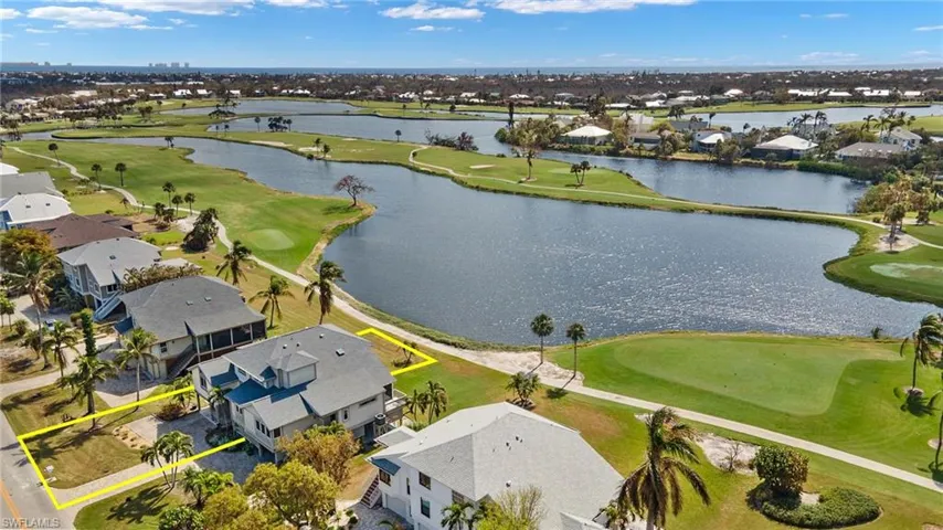 Aerial view of residential area with a golf club and a large body of water