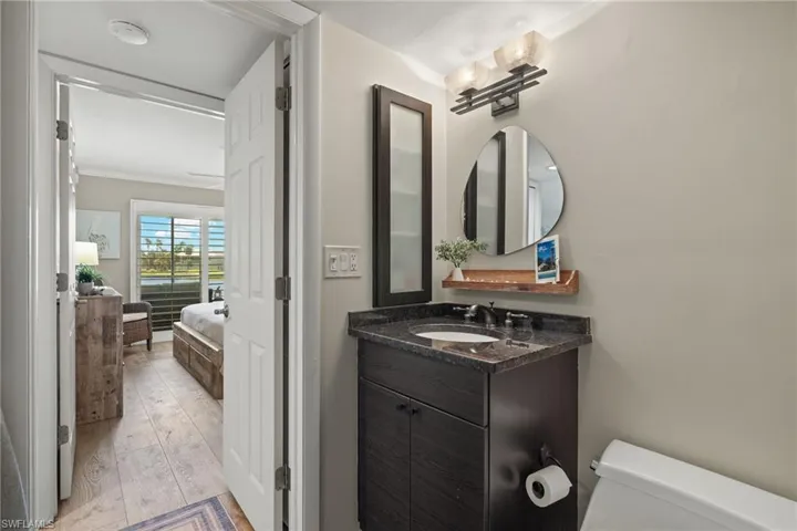 Bathroom with vanity, light wood finished floors, and ensuite bath