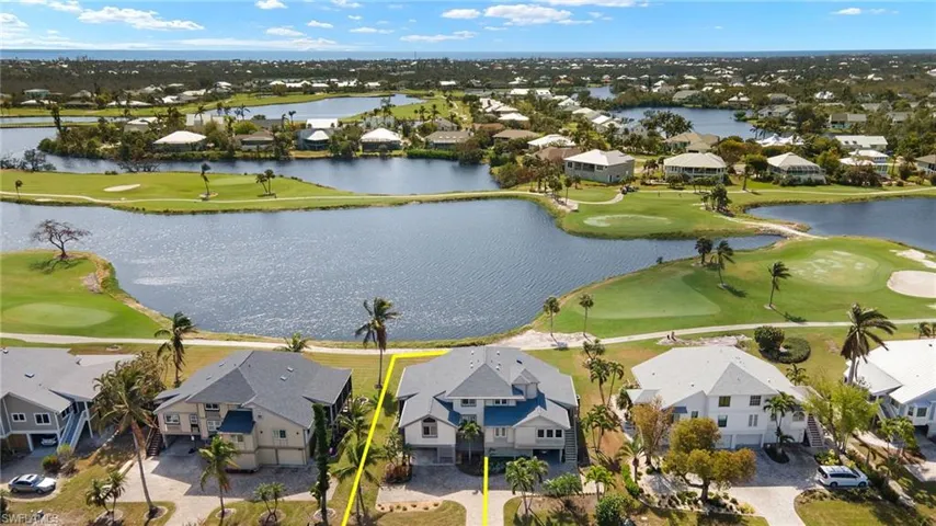 Aerial view of residential area with a local golf course and a nearby body of water