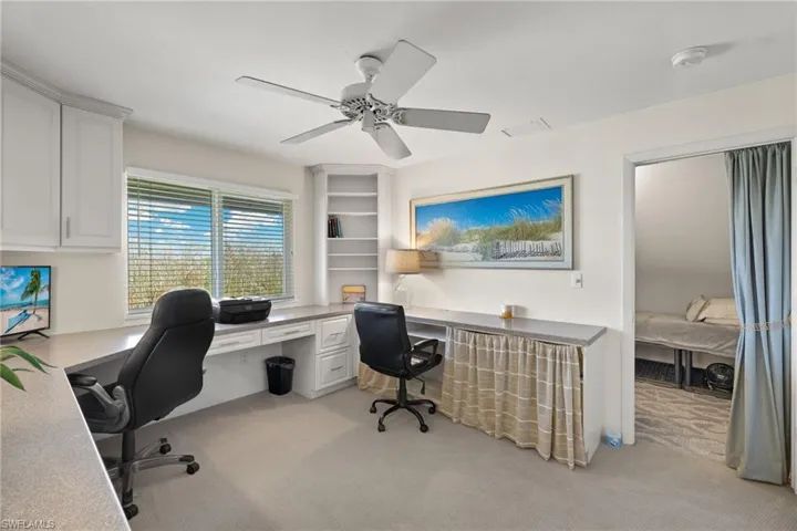 Office space featuring light colored carpet and a ceiling fan