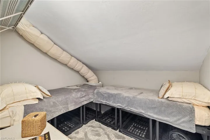 Bedroom with lofted ceiling, a textured ceiling, and carpet floors