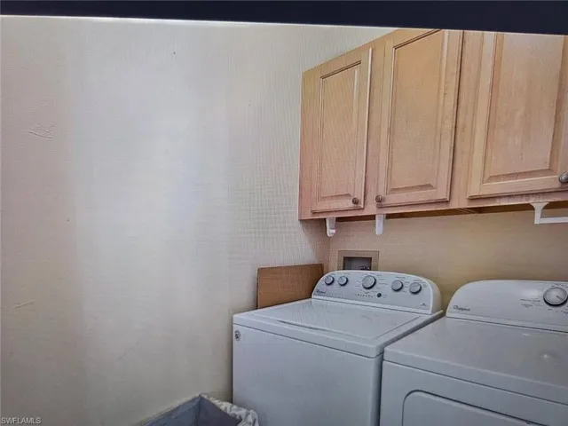 Laundry area featuring separate washer and dryer and cabinet space