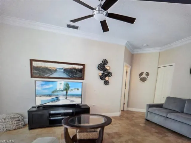 Living area featuring crown molding and ceiling fan