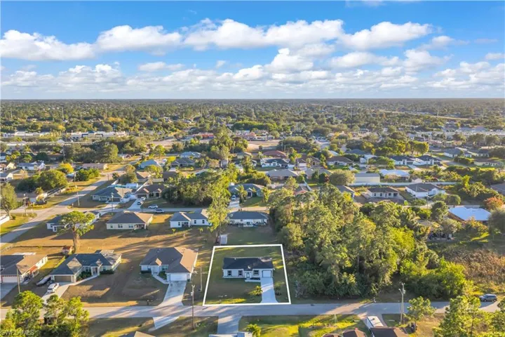 Aerial overview of property's location with nearby suburban area and property parcel outlined