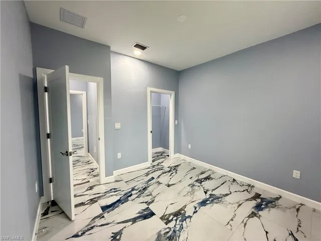 Unfurnished bedroom featuring a walk in closet and a closet