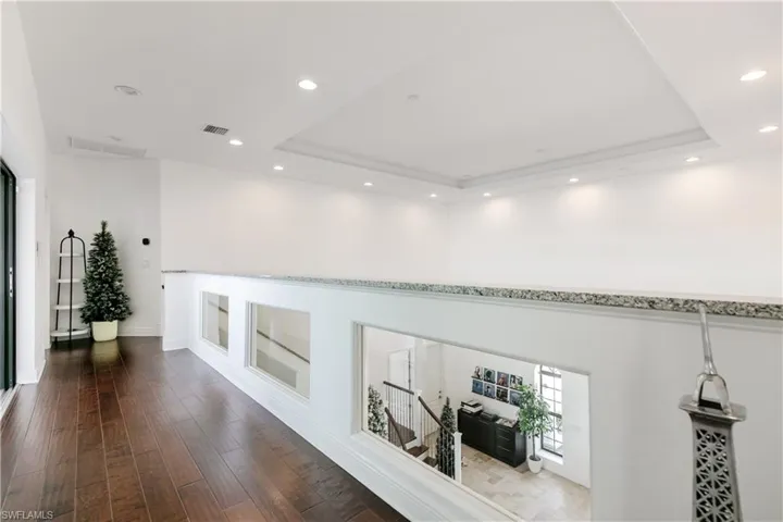 Hall with recessed lighting, dark wood finished floors, and a raised ceiling
