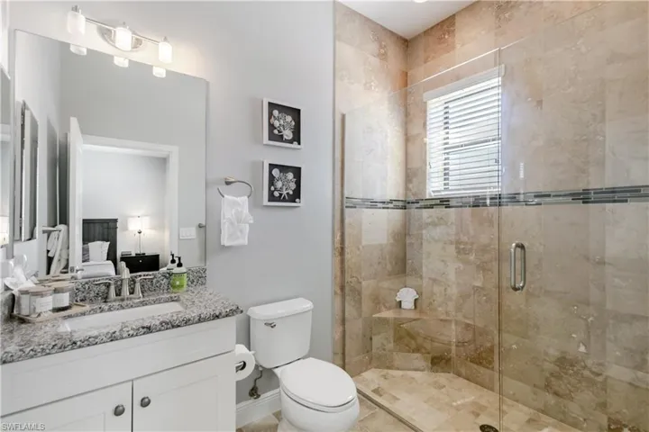 Ensuite bathroom featuring vanity and a shower stall