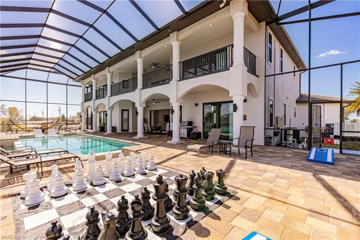 Private poolfeaturing screen enclosure, a patio area, grilling area, and a game area