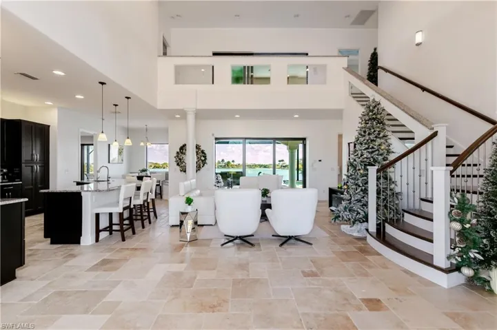 Entryway featuring light stone finish flooring, a high ceiling, and recessed lighting