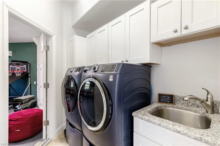 Laundry room featuring washing machine and clothes dryer and cabinet space