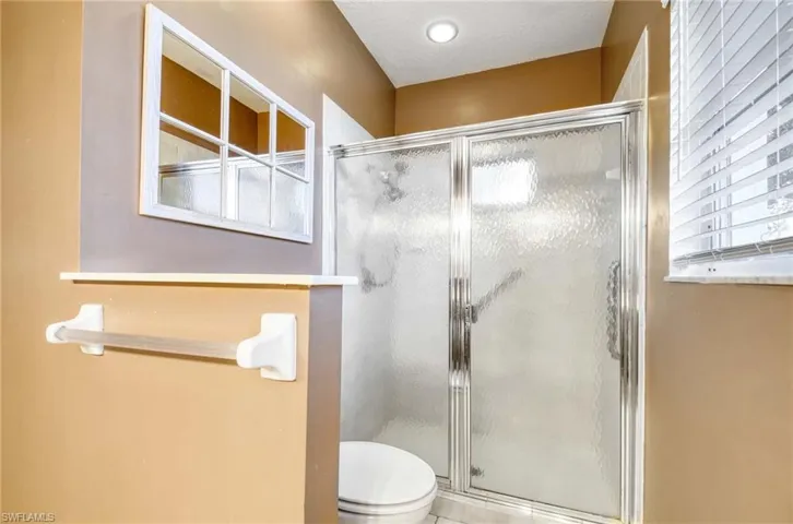 Bathroom with a stall shower and toilet