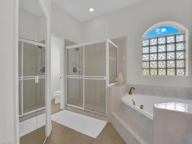 Full bath featuring light tile patterned floors, a bath, a shower stall, and recessed lighting