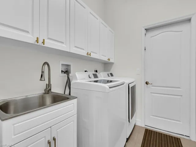 Laundry area featuring cabinet space, washing machine and clothes dryer, and light tile patterned floors