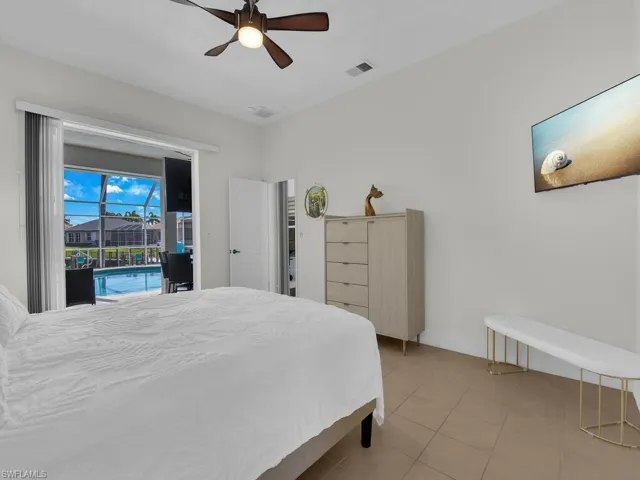 Bedroom featuring access to exterior, a ceiling fan, and light tile patterned floors