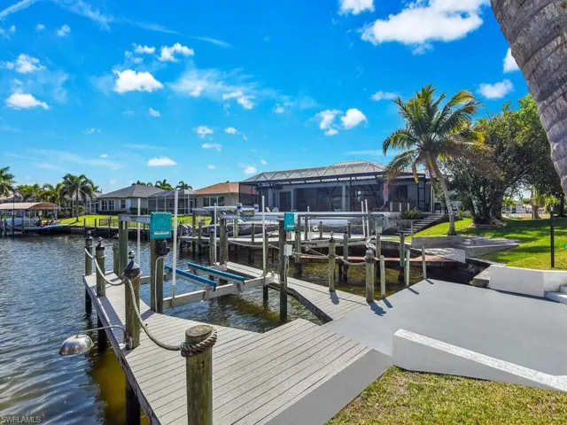 Dock area with a water view, a sunroom, and boat lift