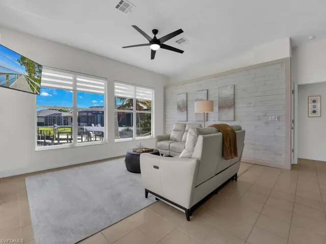 Living room with ceiling fan and light tile patterned floors