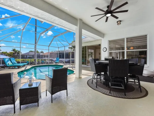 Swimming pool with a patio, a sunroom, outdoor dining area, and a lanai