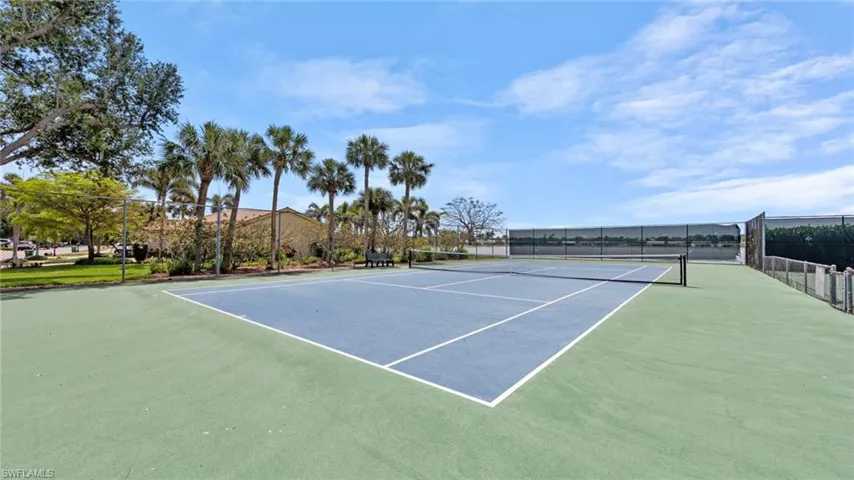 View of tennis court featuring fence