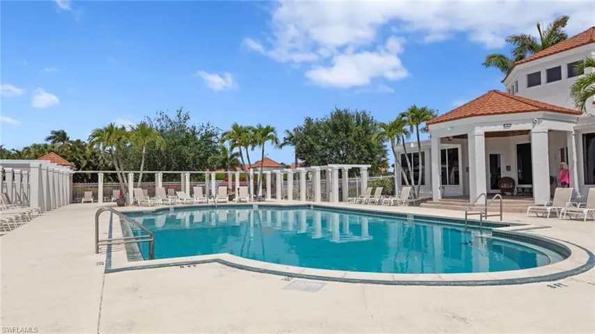 Community pool with fence and a patio area