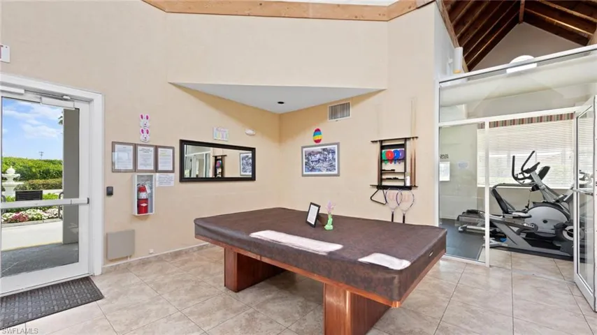 Playroom with high vaulted ceiling, plenty of natural light, billiards, and light tile patterned floors