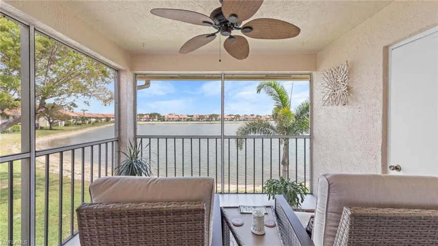 Sunroom with a water view and a ceiling fan