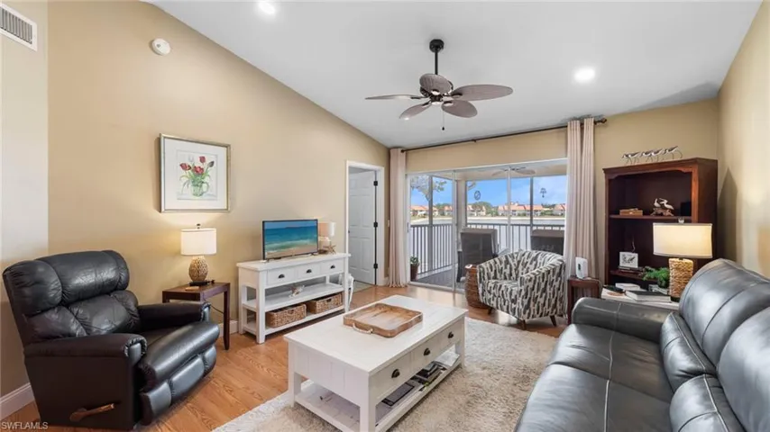 Living room with a ceiling fan, lofted ceiling, light wood finished floors, recessed lighting, and baseboards