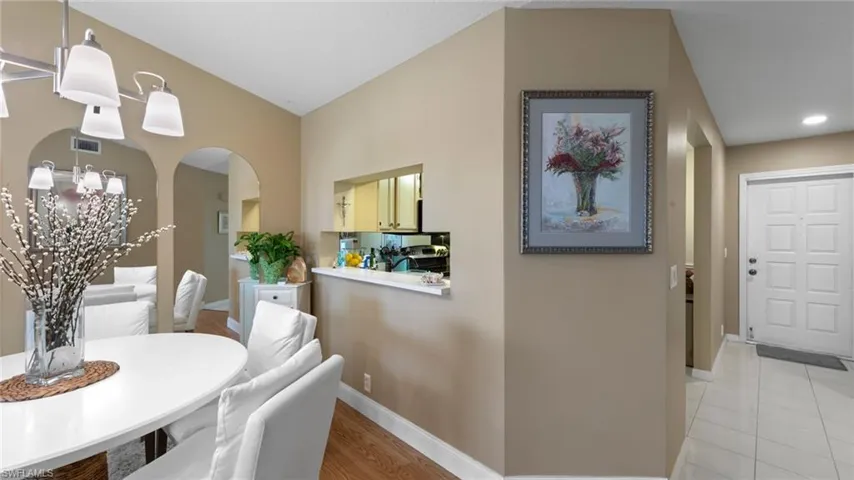 Dining area with arched walkways, baseboards, a chandelier, and recessed lighting