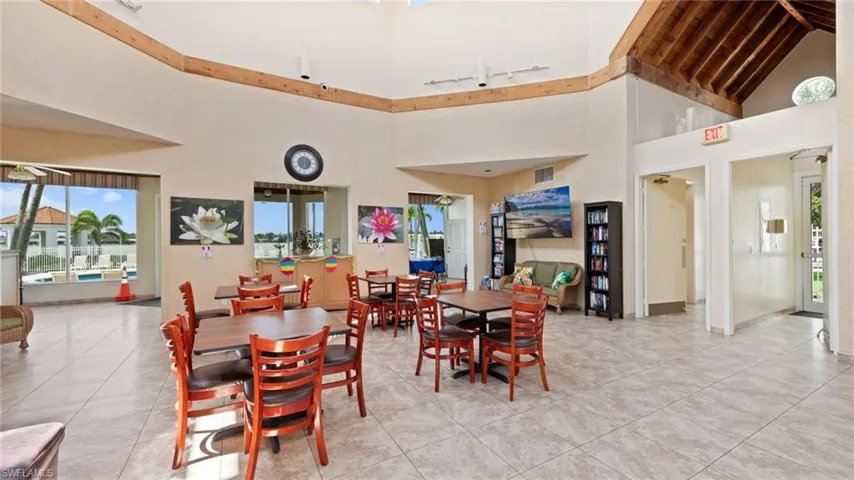 Dining area featuring high vaulted ceiling, light tile patterned flooring, and baseboards