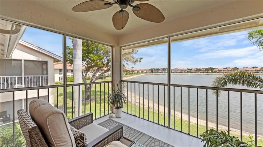 Sunroom with a water view and a ceiling fan