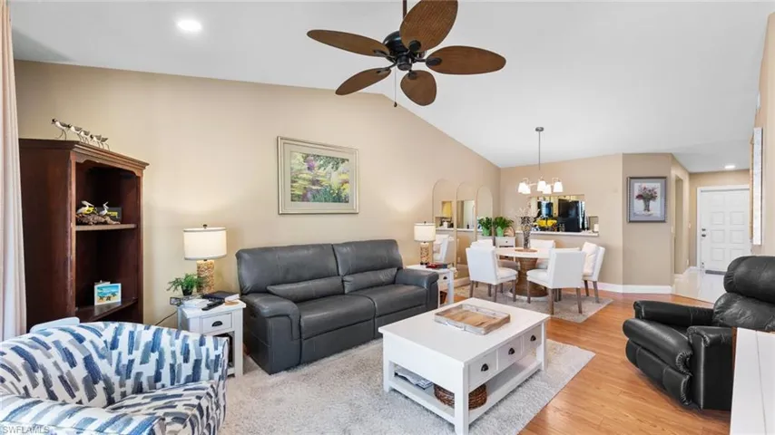 Living area featuring a ceiling fan, light wood-style floors, a chandelier, lofted ceiling, and recessed lighting