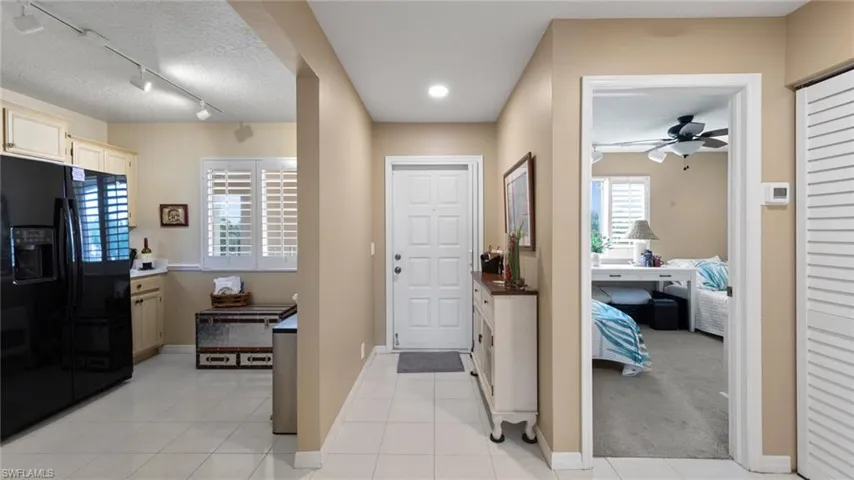 Entrance foyer featuring a ceiling fan, baseboards, a textured ceiling, and light tile patterned floors