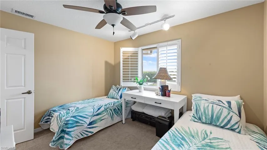 Carpeted bedroom with track lighting and ceiling fan