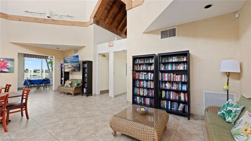 Tiled living room featuring high vaulted ceiling
