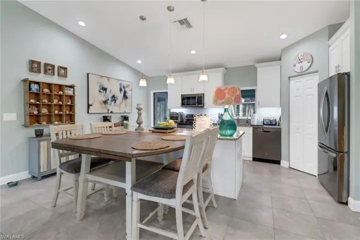 Tiled dining area with lofted ceiling