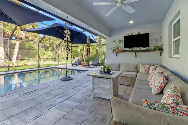 View of pool with a patio, an outdoor living space, a lanai, and ceiling fan