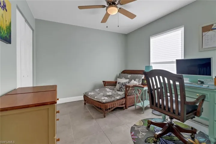 Office with light tile patterned flooring and ceiling fan