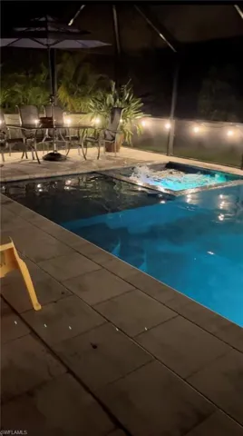 View of swimming pool with a patio area and a jacuzzi