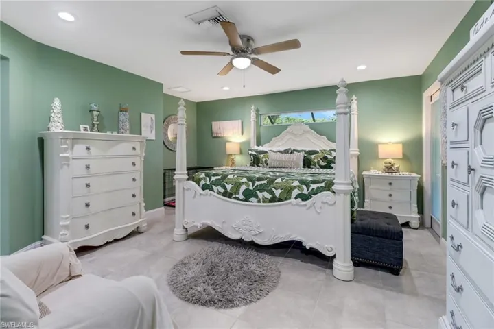 Bedroom with light tile patterned floors and ceiling fan